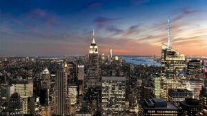 sunset behind nyc skyline with empire state building lit up
